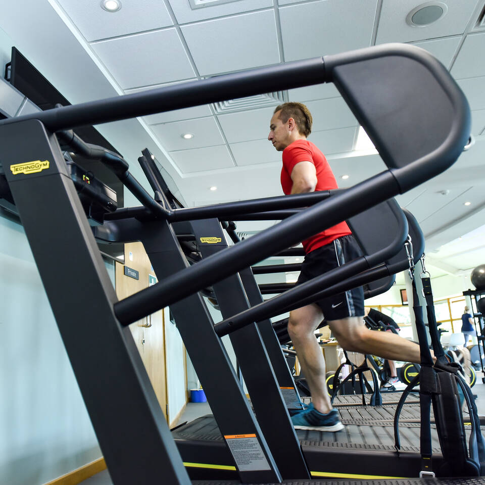 A female health club member running on a treadmill at Nizels Golf and Country Club