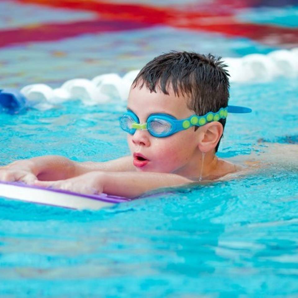 A child learning to swim during a swimming lesson in Nizels Golf and Country Club's swimming pool